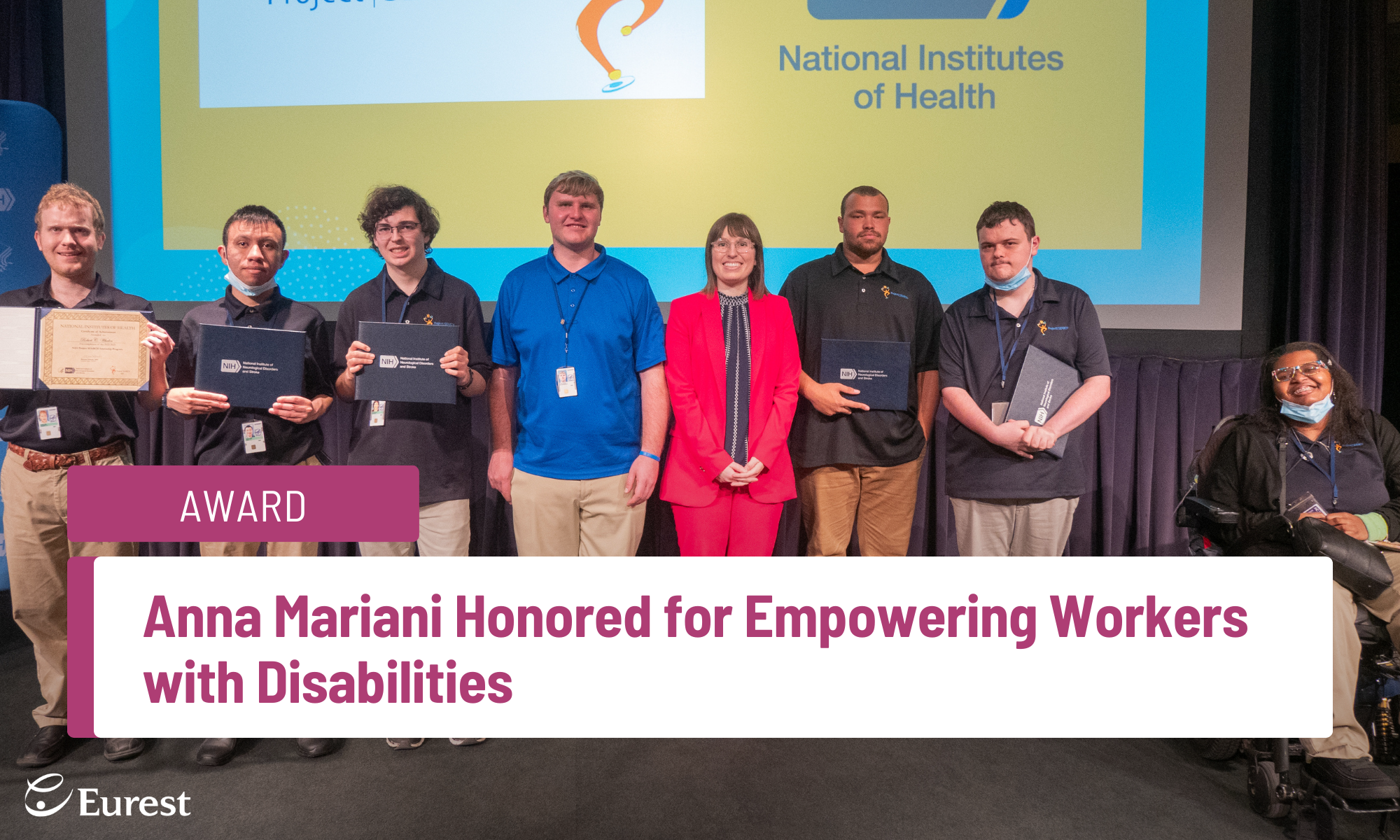 Anna Mariani standing on the stage with group of Project SEARCH interns at the National Institutes of Health